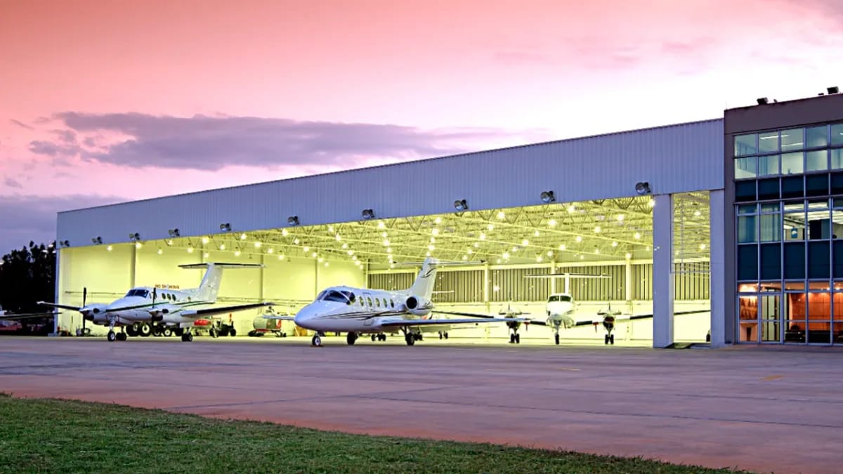 Aircraft hangar built with a pre-engineered metal building system, lit at dusk