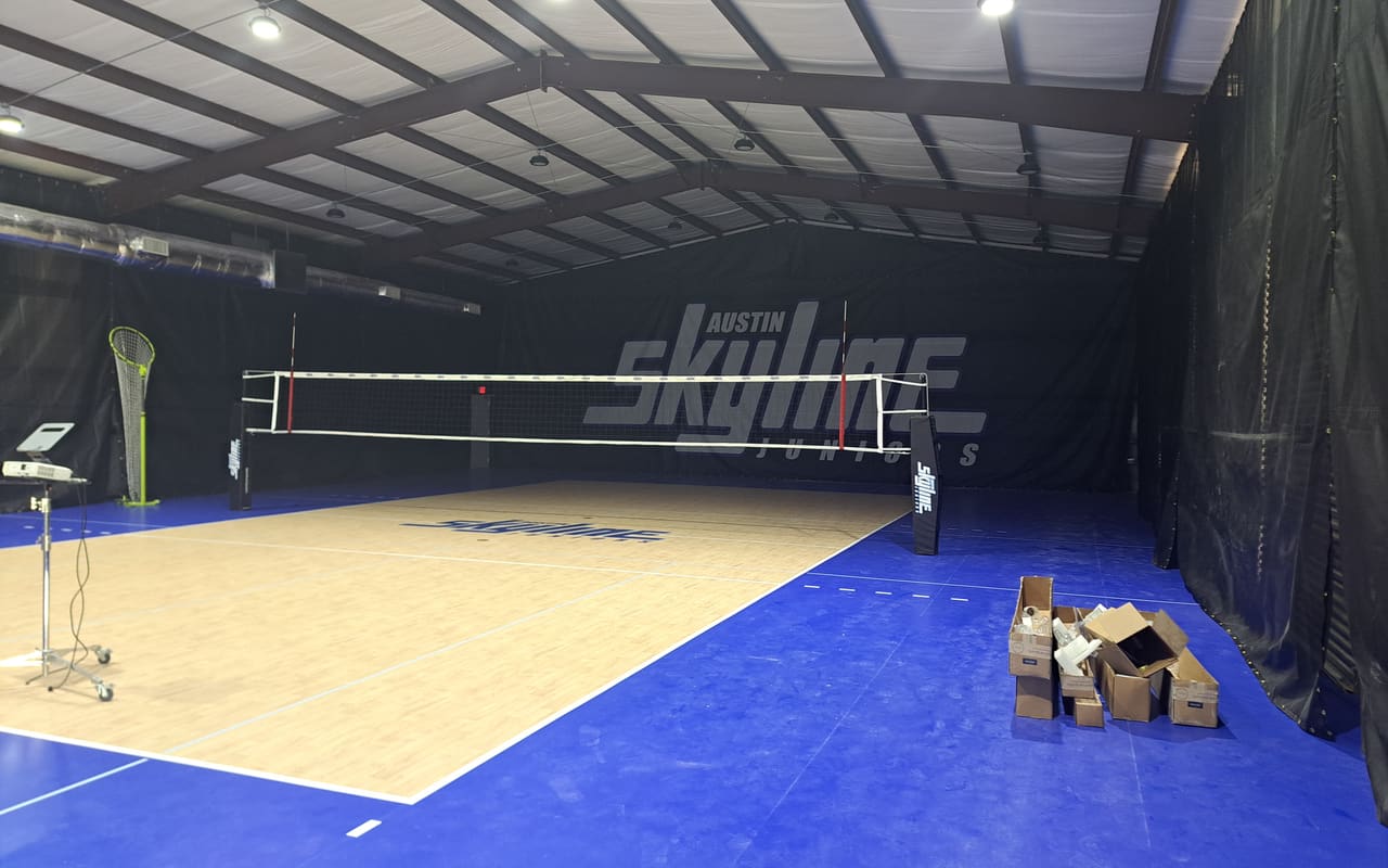 Indoor volleyball court in a newly built sports facility with steel roof framing